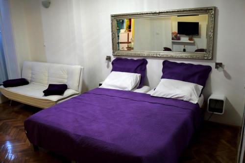 sypialnia z fioletowym łóżkiem i lustrem w obiekcie Apartments Prestige w Splicie