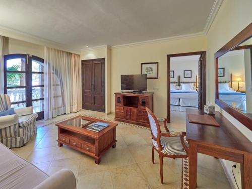 a living room with a couch and a tv at Hotel Bon Sol Resort & Spa in Illetas