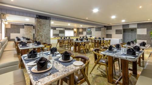 a restaurant with tables and chairs with hats on them at Hotel Presidency-Electronic City Phase II in Bengaluru