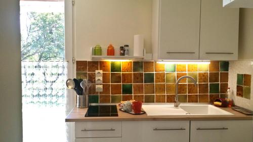 a kitchen counter with a sink and a window at Lou Souleu in Sisteron