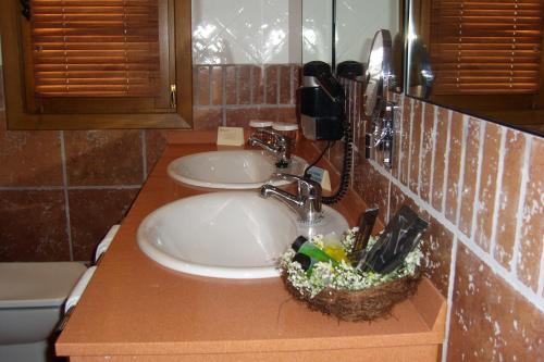 a bathroom with two sinks and a phone on a counter at Hotel Palacio Dos Olivos in Galdeano