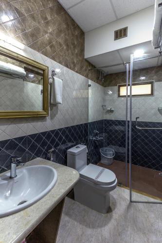 a bathroom with a toilet and a sink at Hotel Presidency-Electronic City Phase II in Bengaluru
