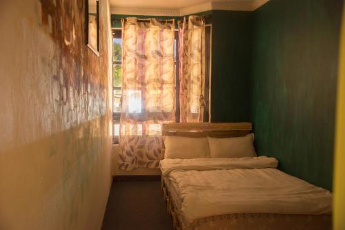 a small room with a bed and a window at Wander Thirst in Kathmandu