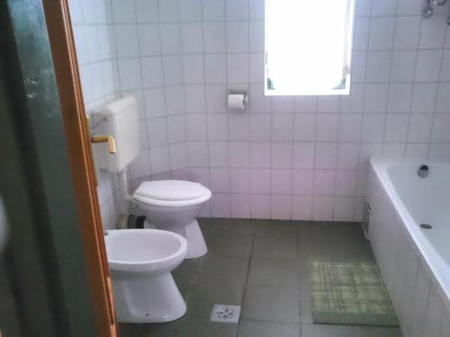 ハイドゥソボスローにあるAquaparti apartmanok Hajdúszoboszlóのバスルーム(トイレ、洗面台、バスタブ付)
