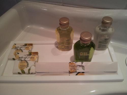 three bottles of honey and a box of mayonnaizers in a refrigerator at Hotel du Poète in Fontaine-de-Vaucluse