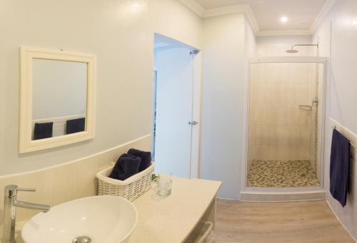 a bathroom with a sink and a shower at Mseni Beach Lodge in Sodwana Bay