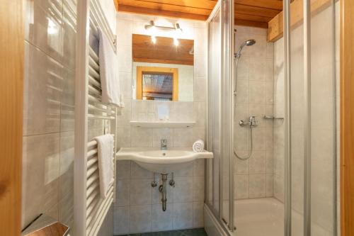 a white bathroom with a sink and a shower at Ferienhof Nasnergut in Radstadt