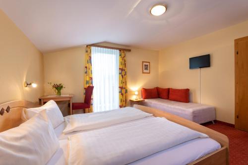 a hotel room with two beds and a couch at Ferienhof Nasnergut in Radstadt