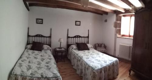 1 dormitorio con 2 camas y ventana en La Casa del Valle, en Ailanes
