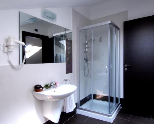 W łazience znajduje się umywalka i przeszklony prysznic. w obiekcie Hotel Villa Pannonia w Lido di Venezia