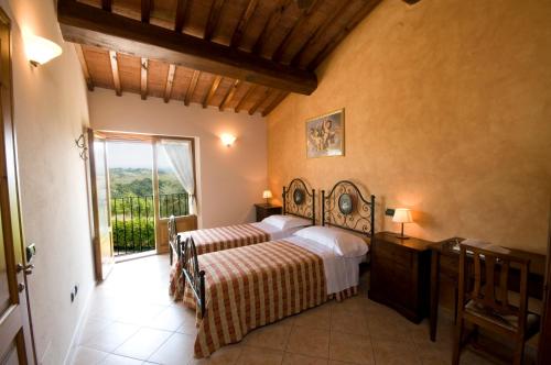 a bedroom with a bed and a large window at Agriturismo Macinatico in San Gimignano