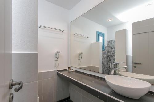 a bathroom with two sinks and a mirror at Naxos Colosseo in Agios Prokopios