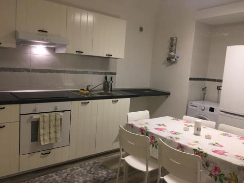 kuchnia ze stołem, krzesłami i zlewem w obiekcie Home sweet home Vietri w mieście Vietri sul Mare