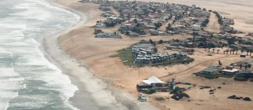 una vista aérea de una playa con casas y el océano en First Group Desert Rose, en Henties Bay