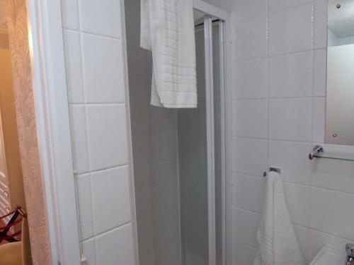 a bathroom with a shower and a white towel at The Berwick - Over 40's Only in Blackpool