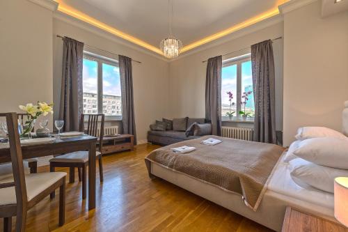 a bedroom with a bed and a table and a desk at Andersa Apartments in Warsaw