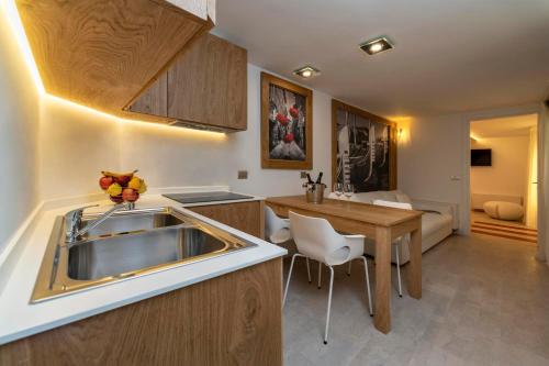 a kitchen with a sink and a wooden table at Ca' de la Fonte - WENICE Deep Culture in Venice