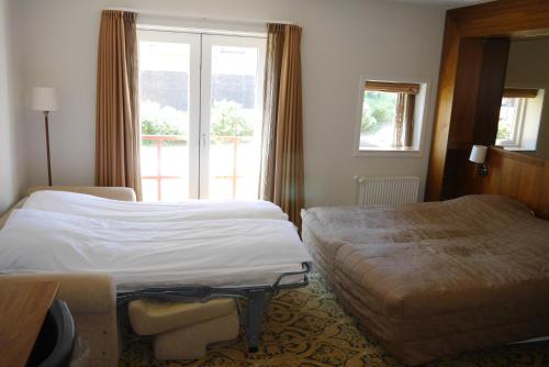 a hotel room with two beds and a window at Montra Odder Parkhotel in Odder