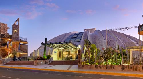 a building with two domes on a city street at H10 Playa Meloneras Palace in Meloneras