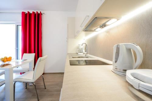 a kitchen with a table and a tv in a room at Villa Niki 2 in Cavtat