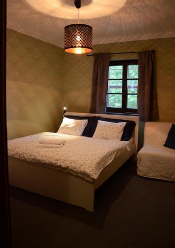a bedroom with a bed and a window and a lamp at Kazmarka in Malá Morávka