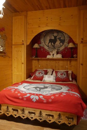 a bedroom with a bed with a red blanket at Chalet la Colombière in Sainte-Agnès