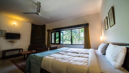 a bedroom with a large bed and a window at Cedar Lodge By Aahma in Rāmgarh