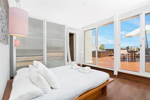 1 dormitorio con cama blanca y ventana grande en Atic Barcelona, en Barcelona