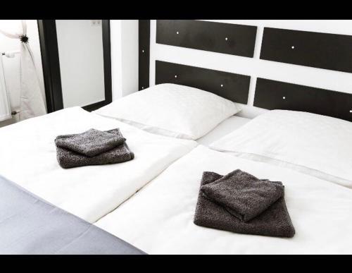 a white bed with two towels on top of it at Schulz Apartments in Bonn