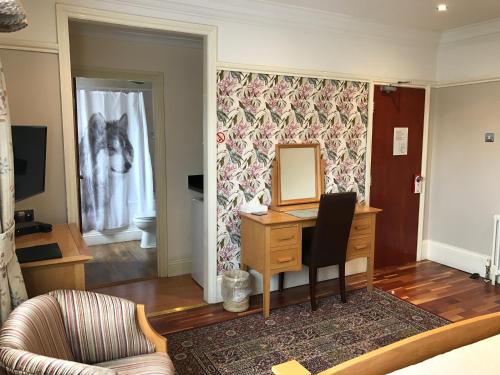 a living room with a desk and a mirror at Acorn Guest House in Hull in Hull