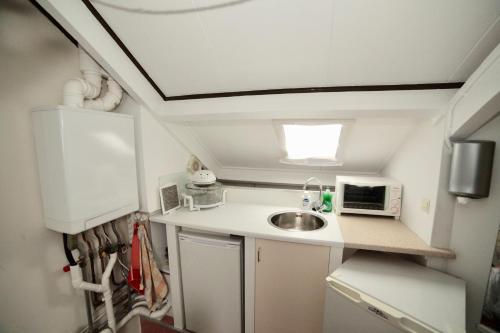 a small kitchen with a sink and a microwave at Kuipers Bed in Volendam