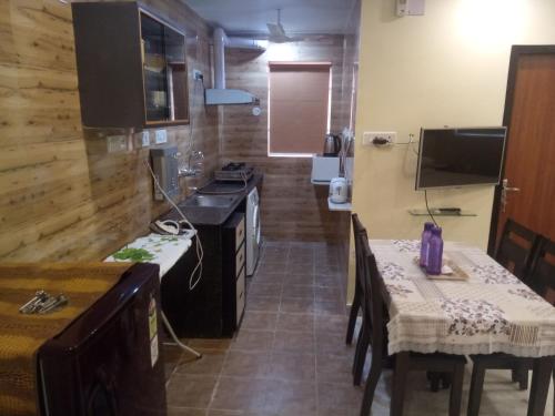 a small kitchen with a table and a stove at Service Apartments, Park Street, Calcutta in Kolkata