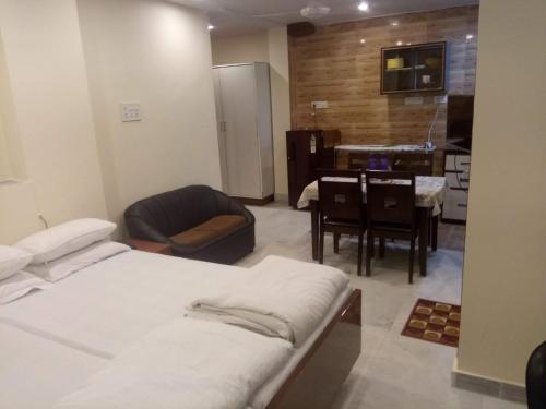 a room with two beds and a kitchen with a table at Service Apartments, Park Street, Calcutta in Kolkata