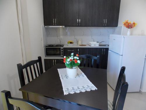 a kitchen with a black table with flowers on it at Relax Apts Saranda in Sarandë