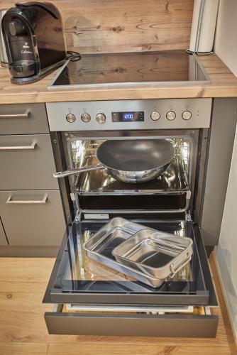 a kitchen with an oven with a pan in it at Appartements Der Fuchsbau in Saalbach Hinterglemm