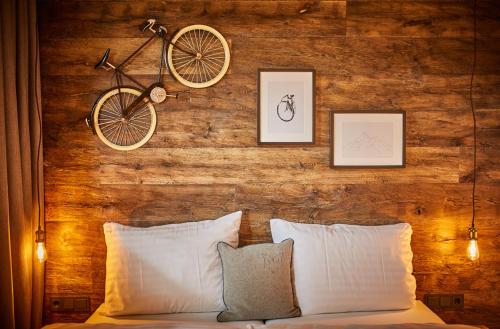 a bicycle hanging on a wooden wall above a bed at Appartements Der Fuchsbau in Saalbach Hinterglemm