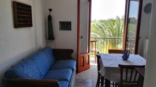 a living room with a blue couch and a table at Residenza al Gelso in Marsala