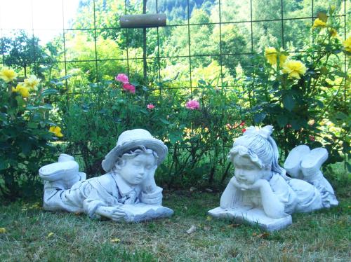 two cherubs sitting in the grass in a garden at Hotel-Restaurant Burg-Ramstein in Kordel
