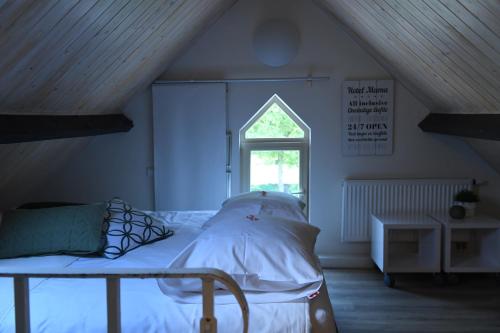 a bedroom with a bed and a window at Vakantiewoningen - Buitenverblijf Huiskenshof Zuid-Limburg in Klimmen