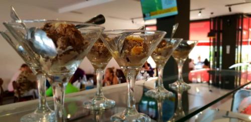 a row of wine glasses with food in them at Domus Hotel & Apartments in Shëngjin