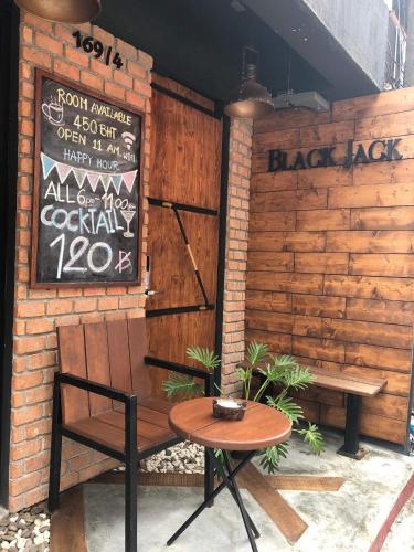a bench and a table in front of a brick wall at Blackjack Bar and Hostel in Chaweng