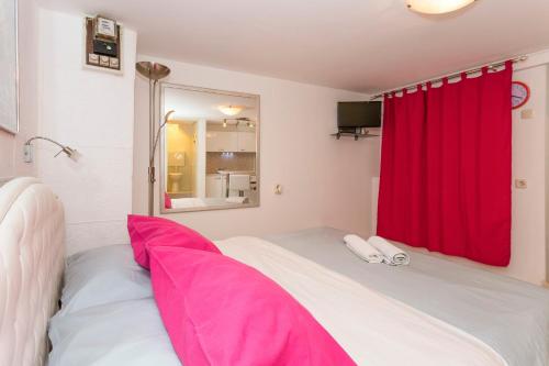 a bedroom with a red curtain and a bed at Studio Varos in Split