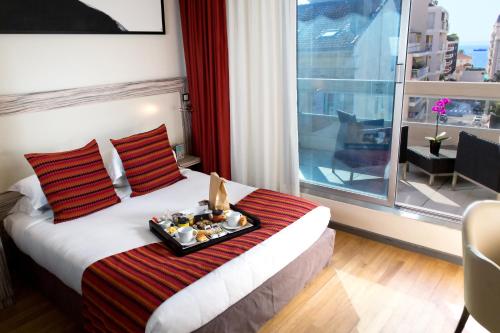 a hotel room with a tray of food on a bed at Eden Hotel & Spa in Cannes