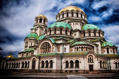 a large building with green domes on top of it at Sunny Central Apartment in Sofia