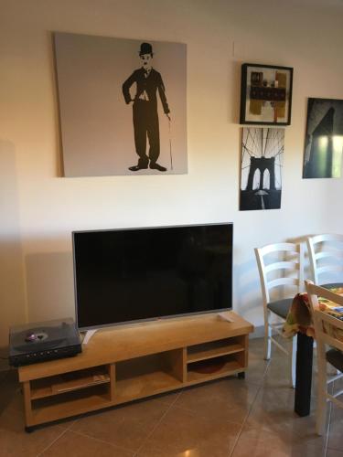 - une télévision à écran plat installée sur un support en bois dans le salon dans l'établissement Casa Vacanze Montesilvano, à Montesilvano
