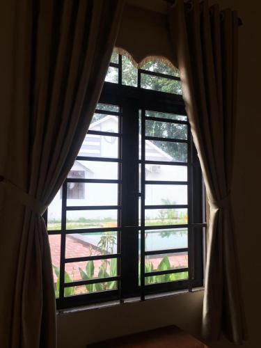 a window with curtains in a room with a view at Hotel Thien Duong Xanh in Bình Chuẩn