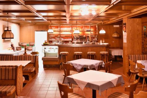 a restaurant with tables and chairs and a kitchen at Residence Terentis in Terento