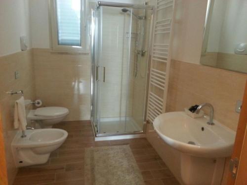 een badkamer met een douche, een toilet en een wastafel bij B&B L'Ulivo in Taviano