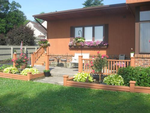 ein Haus mit einer Terrasse mit Blumen im Hof in der Unterkunft Serenity On The Lake in Auburn