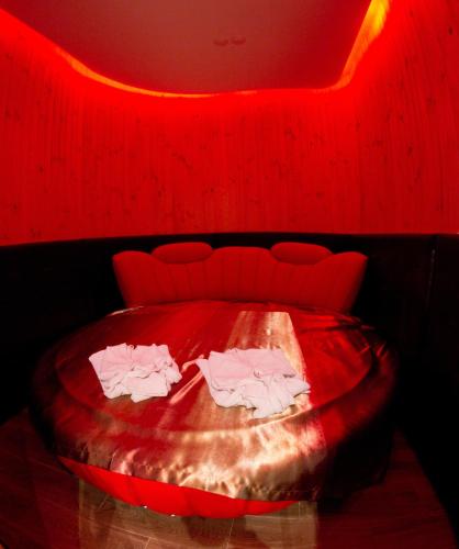 a red room with a bed with two white shirts on it at Boutique Hotel California in Odesa